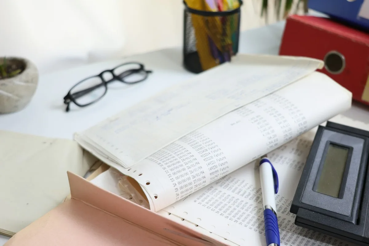 Calculator, financial paperwork and a pen on an office desk