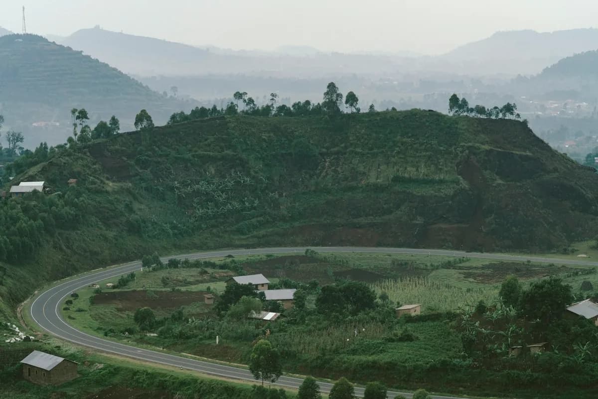 Paved road curving through green hills in Uganda